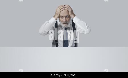 Gestresster verzweifelter Geschäftsmann, der schlechte Nachrichten erhält, ist in Schwierigkeiten Stockfoto