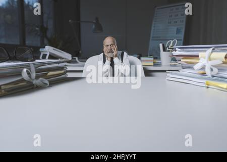 Gestresst erschreckt Geschäftsmann sitzen am Schreibtisch und arbeiten, Geschäftsausfall und Fristen Konzept, leere Kopie Platz Stockfoto