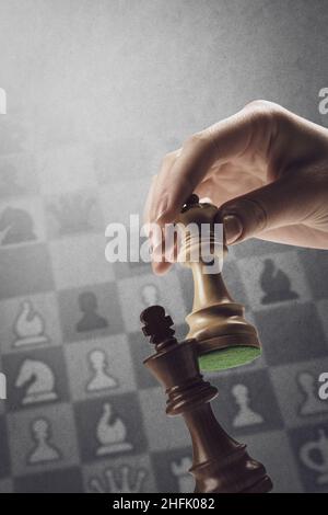 Ein Spieler checkmatet den König während eines Schachspiels: Strategiespiele und Turnierkonzept, Schachdiagramm im Hintergrund Stockfoto