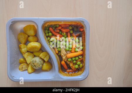 Ein gekochtes Fertiggericht auf einem Holzschreibtisch mit Platz für Kopien. Stockfoto