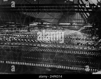 Patons and Baldwins Knitting Factory, Lingfield Close, Darlington, 1947 - 1949. Reihen von Spinnmaschinen im Spinnschuppen in der Strickfabrik Patons und Baldwins. Dies ist eine negative Kopie, die von Laing am 28th. Oktober 1955 gemacht worden zu sein scheint. Das Bild wurde in der März 1949-Ausgabe des monatlichen Laing-Newsletters „Team Spirit“ veröffentlicht. Zum Zeitpunkt der Veröffentlichung waren zwei Drittel der Arbeiten am Standort abgeschlossen und ein kleiner Teil der Fabrik war bereits seit über einem Jahr in Betrieb. Stockfoto