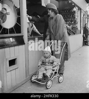 Skegness, East Lindsey, Lincolnshire, 12/06/1948. Eine Frau mit einem Kind in einem Kinderwagen in einem Vergnügungspark während eines Laing-Mitarbeiter-Ausflugs nach Skegness. Eine Gruppe von etwa 100 Personen nahm an diesem Ausflug von Verträgen in Grimsby, Carrington's Coppice, East Leake und Leicester Teil. Stockfoto