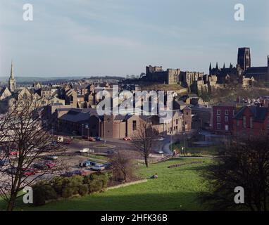 Millburngate, Durham, County Durham, 15/04/1987. Ein erhöhter Blick aus dem Nordwesten, der Millburngate, Riverside House und die umliegenden Gebäude mit Durham Castle im Hintergrund zeigt. Der Bau der zweiten Phase von Millburngate begann im August 1984. Phase I wurde 1974 entwickelt; Phase II würde das Zentrum von 102.000 Quadratfuß auf 187.000 Quadratfuß erweitern. Die zweite Phase war durch eine überdachte Fußgängerzone mit Phase I verbunden. Der fünfstöckige Komplex bestand aus einem Hauptgeschoss mit Geschäften, über dem Lagerraum, und zwei unteren Ebenen mit Parkplätzen und Service, Büros und Restaurants mit Blick auf die Stadt Stockfoto