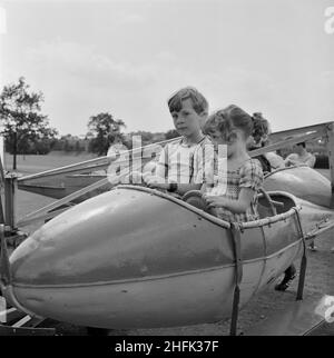 Laing Sports Ground, Rowley Lane, Elstree, Barnett, London, 30/06/1984. Zwei Kinder in einem Modellflugzeug auf dem Messegelände fahren bei einem Gala-Tag auf dem Laing Sports Ground in Elstree. Laings jährlicher Sommer-Gala-Tag fand am 30th. Juni 1984 im Laing Sports Club in Rowley Lane statt. Der Tag beinhaltete Sportwettkämpfe für Erwachsene und Kinder, 31 Stände, Wohltätigkeitsveranstaltungen und ein abendliches Barbecue. Über 2.000 Menschen nahmen an dem Gala-Tag Teil. Stockfoto