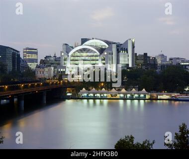 Embankment Place, City of Westminster, London, 01/09/1990. Ein Blick auf die fertig gestellte Embankment Place-Entwicklung in der Abenddämmerung, aufgenommen von der anderen Seite der Themse. Im Jahr 1987 gewann Laing Management Contracting den Auftrag für den Bau des Embankment Place über Charing Cross Station. Der Damm Place ist überwiegend ein Bürogebäude, obwohl die Arbeiten am Standort auch den Bau von Einkaufsmöglichkeiten, die Renovierung des Players Theatre und Verbesserungen am Bahnhof selbst beinhalteten. British Rail arbeitete während des gesamten Vertrags eng mit Laing zusammen. Die Website wurde 1991 fertiggestellt und ging weiter zu wi Stockfoto