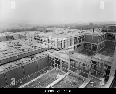 County High School, Gedling Road, Arnold, Gedling, Nottinghamshire, 23/02/1959. Ein Blick nach Südwesten von einem oberen Fenster im Wissenschaftsblock an der Arnold County High School, der Arbeiter zeigt, wie sie Kies auf den Dächern niederer Schulgebäude verteilen. Die Arbeiten auf dem Gelände begannen im März 1958 und die Bauarbeiten für das neue Schuljahr im September 1959 wurden abgeschlossen. Das koedukative Gymnasium beherbergte 720 Schüler. Mitte 1960s wurde in der Nähe eine weitere Schule gebaut und 1974 wurden die beiden zu einem umfassenden Schulgebäude zusammengebaut. Die von Laing errichteten Schulgebäude wurden schließlich 2017 abgerissen. Stockfoto