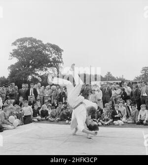 Laing Sports Ground, Rowley Lane, Elstree, Barnett, London, 17/06/1961. Eine Menschenmenge, die während eines Sporttages in Laing in Elstree eine Judo-Demonstration von zwei Mitgliedern der Metropolitan Police beobachtet. Dieses Bild wurde im Juli 1961 in Laings monatlichem Newsletter „Team Spirit“ veröffentlicht. Stockfoto
