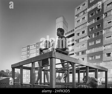 Doddington Estate, Battersea, Wandsworth, London, 08/09/1971. Kinder spielen auf einem Klettergerüst auf dem Doddington Estate, hinter dem ein 10-stöckiges und 13-stöckiges Wohngebäude steht, das mit dem 12M Jespersen-System gebaut wurde. Das Doddington Estate, direkt an der Battersea Park Road, wurde von den Architekten Emberton, Tardrew &amp; Partners entworfen. Das Anwesen, zu dem auch Wohntürme gehörten, wurde zwischen 1967-71 von Laing für den Wandsworth London Borough Council erbaut. Es wurde mit ihrem 12M Jespersen-Bausystem gebaut, das aus vorgefertigten Teilen und Betonfertigteilen besteht, die auf ihrem Beton hergestellt wurden Stockfoto