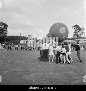 Laing Sports Ground, Rowley Lane, Elstree, Barnett, London, 22/06/1963. Ein Blick auf ein pushball-Spiel, bei dem der Ball über die Köpfe der Teilnehmer gehoben wurde, während des jährlichen Laing Sports Day auf dem Laing Sports Ground in Elstree. Im Jahr 1964 wurde Laings jährlicher Sporttag am 22nd. Juni auf dem Sportplatz auf der Rowley Lane in Elstree abgehalten. Zu den Veranstaltungen gehörten Kinderrennen, Tennis zwischen den Filialen, ein Fußballwettbewerb, ein Sportprogramm und Boule. Das Oxford-Team gewann den pushball-Wettbewerb. Stockfoto