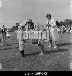 Laing Sports Ground, Rowley Lane, Elstree, Barnett, London, 22/06/1963. Ein junges Mädchen, gekleidet als Kosmonaut Valentina Tereshkova, erhielt einen Preis von Hilda Laing nach einem Kostümwettbewerb beim jährlichen Laing-Sporttag in Elstree. Im Jahr 1964 wurde Laings jährlicher Sporttag am 22nd. Juni auf dem Sportplatz auf der Rowley Lane in Elstree abgehalten. Zu den Veranstaltungen gehörten Tennis zwischen den Außenstellen, ein Fußballwettbewerb, ein Sportprogramm und Boule. Es gab Sport- und Sportveranstaltungen für Kinder, sowie Wettbewerbe für ausgefallene Kleidung. Eine Woche vor der Aufnahme dieses Fotos wurde Valentina Tereshkova zur Fifi Stockfoto