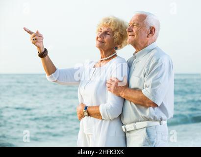 Männchen und Weibchen zeigen mit dem Finger auf den Ozean Stockfoto