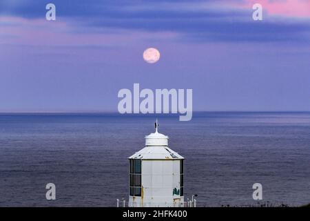 Trevose Head, Cornwall, Großbritannien. 17th. Januar 2022. Wetter in Großbritannien. Der fast vollwölfige Mond, der heute Morgen über dem Leuchtturm von Trevose Head an der Nordküste von Cornwall untergeht. Kredit Simon Maycock / Alamy Live Nachrichten. Stockfoto