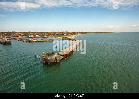 Blick vom abfahrenden Schiff über den Rostocker Hafen in Warnemünde. Sonnenschein und ruhige Ostsee während der Überfahrt nach Skandinavien Stockfoto