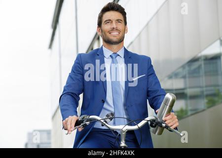 Mann in formeller Kleidung auf dem Fahrrad Stockfoto