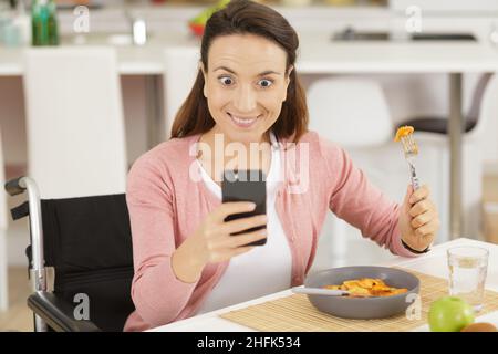Deaktivieren Sie Frau Spaghetti essen mit Smartphone für Selfie Stockfoto