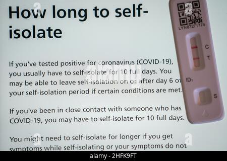 Eine positive laterale Testkassette, die neben Empfehlungen der NHS-Website in London platziert wurde. Die britische Gesundheitsbehörde hat gesagt, dass Menschen in England möglicherweise die Selbstisolation am oder nach dem 6. Tag Ihrer Selbstisolationszeit verlassen können, wenn Sie 2 negative Tests am 5. Und 6. Tag haben. Bilddatum: Montag, 17. Januar 2022. Stockfoto
