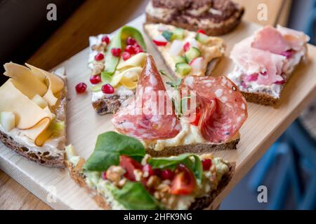 Teller mit offenen, farbenfrohen Sandwiches im skandinavischen Stil. Stockfoto