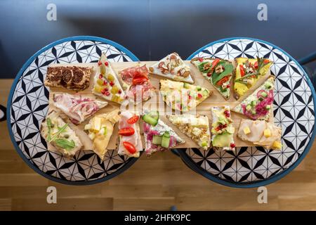 Teller mit offenen, farbenfrohen Sandwiches im skandinavischen Stil. Stockfoto