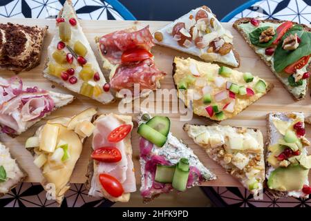 Teller mit offenen, farbenfrohen Sandwiches im skandinavischen Stil. Stockfoto