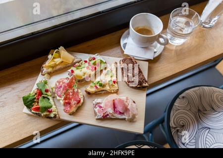 Teller mit offenen, farbenfrohen Sandwiches im skandinavischen Stil. Stockfoto