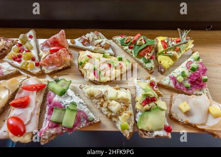 Teller mit offenen, farbenfrohen Sandwiches im skandinavischen Stil. Stockfoto