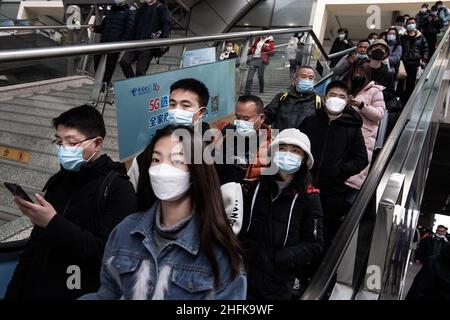Wuhan, China. 17th Januar 2022. Maskierte Fahrgäste fahren auf einer Rolltreppe am Bahnhof Hankow in Wuhan.die Zahl der Bahnpassagierfahrten während des Frühjahrsfests 2022 der Reiseansturm wird voraussichtlich 280 Millionen erreichen, mit durchschnittlich 7 Millionen Fahrten pro Tag, was einem Anstieg von 28,5 Prozent gegenüber dem Vorjahr entspricht, so die Eisenbahnbehörden. Millionen von Chinesen werden während der Frühlingsfeiertage, die mit dem Mondneujahr am 1. Februar beginnt, nach Hause reisen, um Familien in Massen zu besuchen. Kredit: SOPA Images Limited/Alamy Live Nachrichten Stockfoto