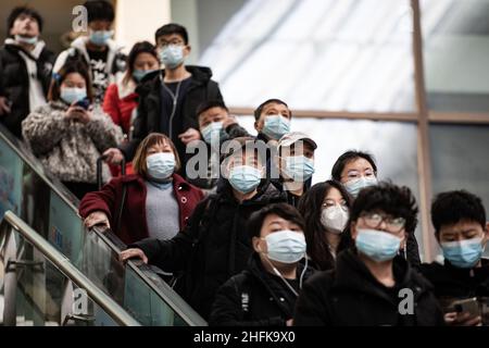 Wuhan, China. 17th Januar 2022. Maskierte Fahrgäste fahren auf einer Rolltreppe am Bahnhof Hankow in Wuhan.die Zahl der Bahnpassagierfahrten während des Frühjahrsfests 2022 der Reiseansturm wird voraussichtlich 280 Millionen erreichen, mit durchschnittlich 7 Millionen Fahrten pro Tag, was einem Anstieg von 28,5 Prozent gegenüber dem Vorjahr entspricht, so die Eisenbahnbehörden. Millionen von Chinesen werden während der Frühlingsfeiertage, die mit dem Mondneujahr am 1. Februar beginnt, nach Hause reisen, um Familien in Massen zu besuchen. Kredit: SOPA Images Limited/Alamy Live Nachrichten Stockfoto