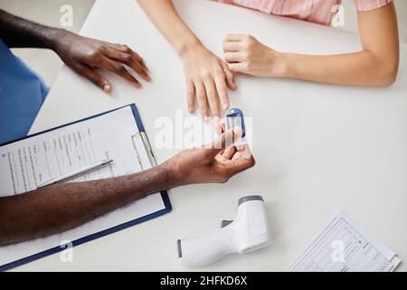 Draufsicht Nahaufnahme eines nicht erkennbaren Arztes, der die Sauerstoffsättigung misst, während er einen Kinderpatienten in einer medizinischen Klinik untersucht, Platz kopieren Stockfoto