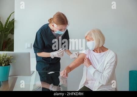 Ältere Frau, die sich zu Hause impfen ließ Stockfoto