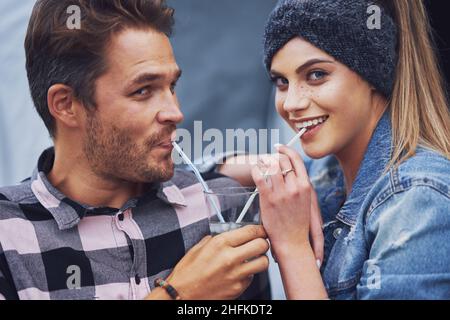 Junges nettes Paar mit Spaß auf Camping Sharing Drink Stockfoto