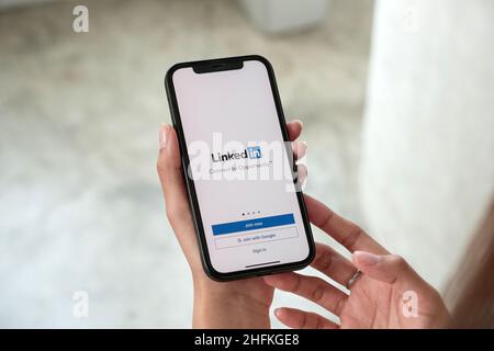 CHIANG MAI, THAILAND, 15. JANUAR 2022 : Eine Frau hält Apple iPhone 13 Pro max mit LinkedIn-Anwendung auf dem Bildschirm.LinkedIn ist eine Foto-Sharing-App für Stockfoto
