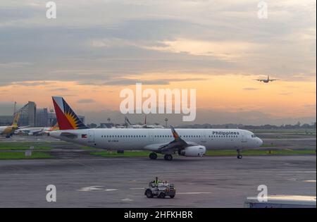 Philippine Airlines Airbus A321 steht am frühen Morgen vor Sonnenaufgang im Terminal 2 des internationalen Flughafens Ninoy Aquino in Manil zur Abfahrt bereit Stockfoto