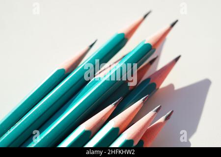Grünes Set von Graphitstiften auf einem sonnigen weißen Tisch. Stockfoto