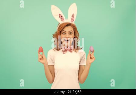 Überrascht Rothaarige Frau in Hasen Kaninchenohren mit bemalten Eiern, frohe ostern Stockfoto