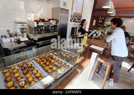 Krakau. Krakau. Polen. Innen Cupcake Bäckerei und Cafe. Kunde, Verkäuferin und Cupcakes an der Theke Stockfoto