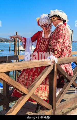 Mann und Frau im historischen venezianischen Kostümkleid im Barockstil, Pose an der Lagune beim Karneval in Venedig, Carnevale di Venezia, Italien Stockfoto