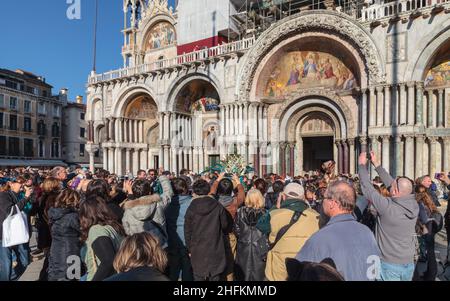 Fotografen, Touristen und Besucher drängen sich in der Basilika auf dem Markusplatz, dem Karneval von Venedig, Italien, um einen Teilnehmer in Kostümen Stockfoto