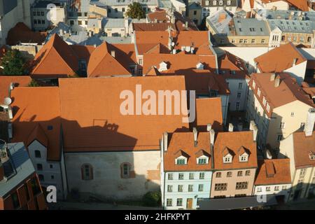 Eine Luftaufnahme der Ziegeldächer und Fassaden historischer Gebäude. Die Landschaft von Riga in der Innenstadt der antiken Architektur in Lettland in der Luft. Stockfoto