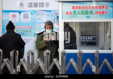 (220117) -- PEKING, 17. Januar 2022 (Xinhua) -- Ein Mitarbeiter (1st R) führt einen Passagier, um einen QR-Code für die Gesundheit an einem Eingang des Westbahnhofs von Peking in Peking, der Hauptstadt von China, zu zeigen, 17. Januar 2022. Die chinesische Reisesaison für das Frühlingsfest 2022 wird voraussichtlich 1,18 Milliarden Fahrgastreisen verzeichnen, ein Anstieg von 35,6 Prozent im Vergleich zum Vorjahr, aber 20,3 Prozent weniger als im Jahr 2020, teilte das Verkehrsministerium mit. Die 40-tägige Reisesaison, auch bekannt als chunyun, begann am Montag und viele Menschen werden reisen, um sich mit ihren Familien zum Lunar New Year oder zum Frühlingsfest, das im Februar stattfindet, zu vereinen Stockfoto