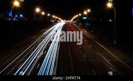 Nachtverkehr. Ampeln auf einer großen Straße. Blick von oben. Weiße und rote Ampeln, Linien. Stockfoto