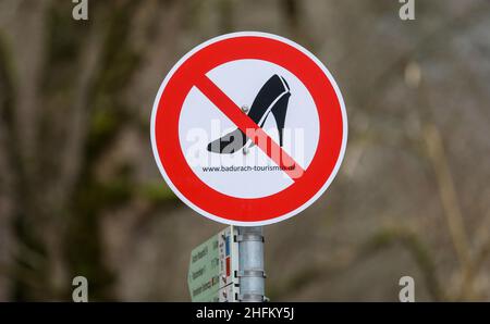 Bad Urach, Deutschland. 16th Januar 2022. Ein Schild mit durchgestrichenen hohen Schuhen weist die Besucher des Wasserfalls in Bad Urach darauf hin, dass der Weg nur mit geeignetem Schuhwerk zu beschreiten ist. Der Urach-Wasserfall gehört zu den Sehenswürdigkeiten des UNESCO-Weltgeoparks Schwäbische Alb und des von der UNESCO anerkannten Biosphärenreservats Schwäbische Alb. Quelle: Thomas Warnack/dpa/Alamy Live News Stockfoto