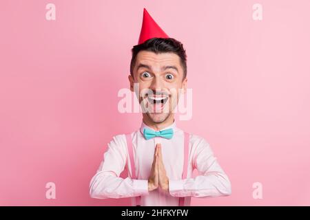 Portrait von aufgeregt Mann riesigen Kopf erwartet Geschenke tragen roten Geburtstag Hut isoliert rosa farbigen Hintergrund Stockfoto