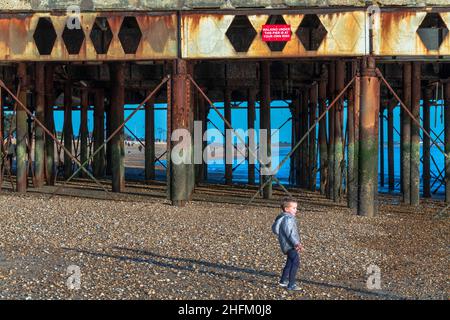 Ein Solitary Boy spielt am Strand vor dem South Parade Pier, Southport, Hampshire. Stockfoto