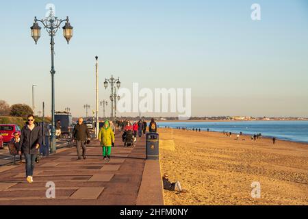 Menschen, die an der Eastney Esplanade bei Sonnenuntergang, Southsea, Hampshire, spazieren. Stockfoto