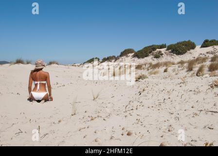 Junge Frau am weißen Sandstrand von Porto Pino, Sardinien Stockfoto