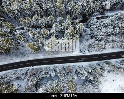 Straße mit Wald im Winter von oben Stockfoto