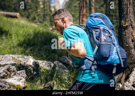 Mann mit Rucksack beim Wandern im Wald Stockfoto