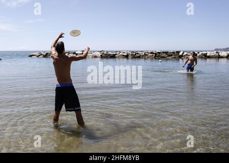 Cecilia Fabiano/LaPresse Juni 12 , 2020 Rome (Italy) News Phase 3 , neues Protokoll ermöglicht es, Strandspiel im Pic zu spielen : Jungen spielen Frisbee am Strand Stockfoto