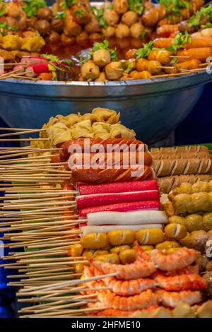 Auswahl an thailändischen Speisen auf einem Lebensmittelmarkt auf der Insel phuket in thailand, Snacks und Buffetspeisen auf einem Street Food Stand in thailand. Stockfoto