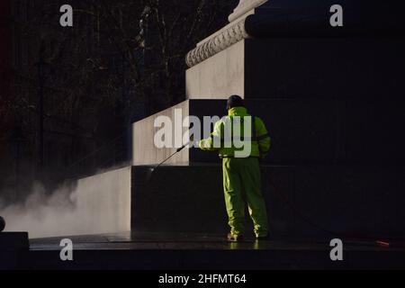 London, Großbritannien 17th. Januar 2022. Ein Arbeiter reinigt die Basis der Nelson-Säule am Trafalgar Square, einem beliebten Ort für Touristen zum Klettern. Kredit: Vuk Valcic / Alamy Live Nachrichten Stockfoto